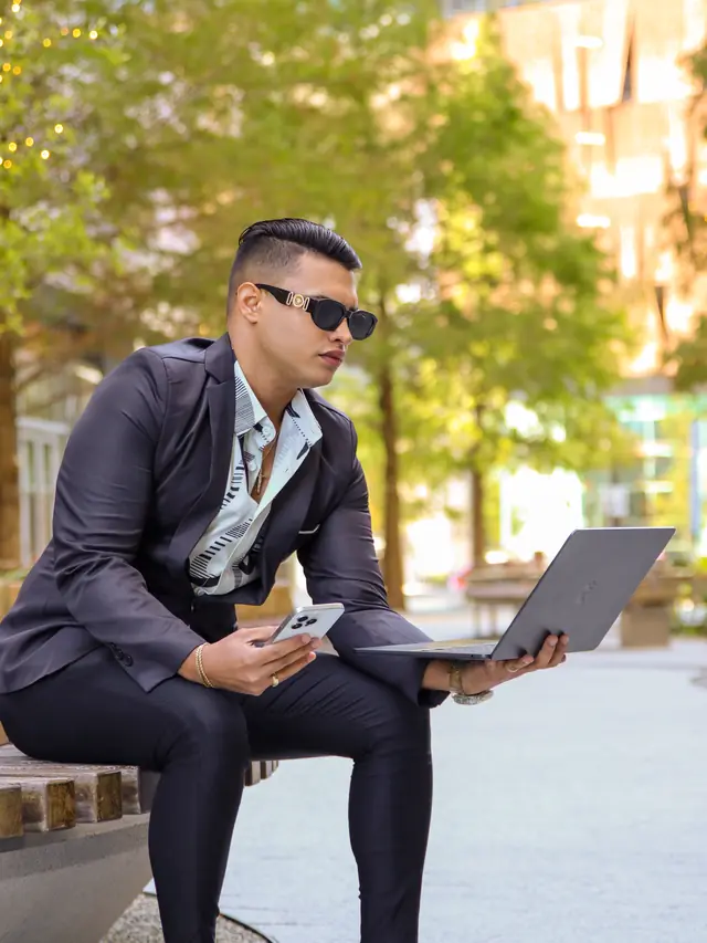 Alex trabajando al aire libre con portátil y teléfono